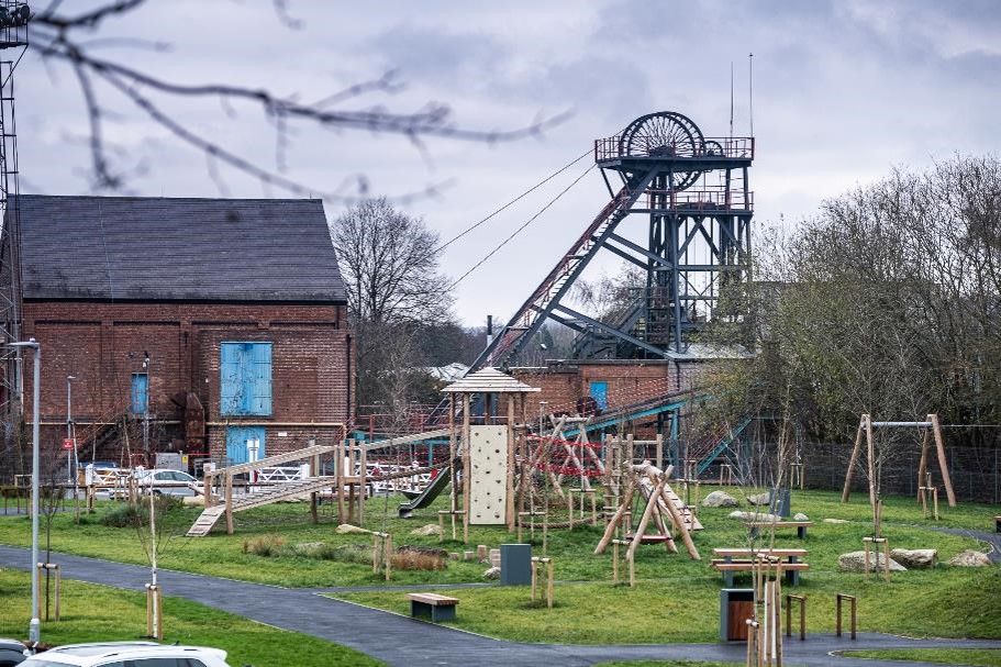 The play area at Snibston Colliery Park with the colliery machinery in the background.