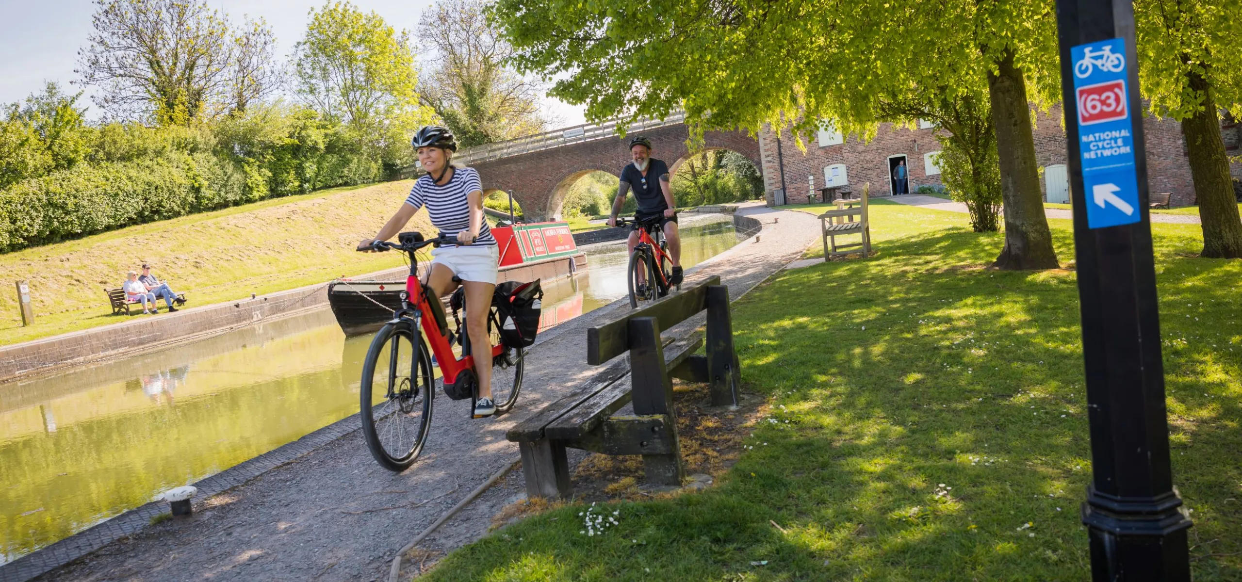 2 people on e-bikes on the canal tow path at Moira furnace